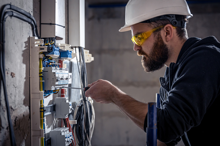 An electrician performing an inspection to ensure a home’s electrical panel and wiring meet modern safety and efficiency standards.